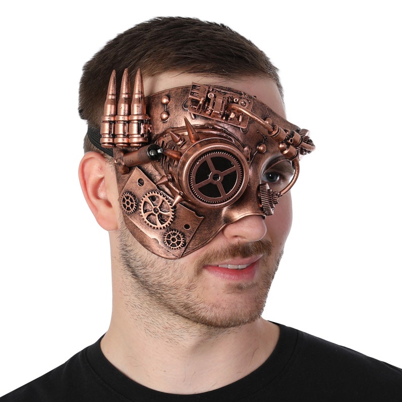 May include: A copper-colored steampunk-style masquerade mask with gears, a circular lens, and a row of bullet casings on the side.