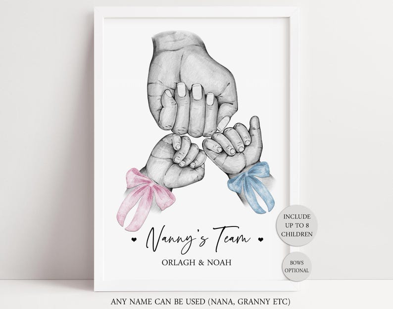 May include: A framed print featuring a black and white pencil sketch of one large hand holding two smaller hands. The smaller hands have pink and blue bows tied around the wrists. Text reads Nanny's Team, Orlagh & Noah, Include up to 8 children, Bows optional, Any name can be used.