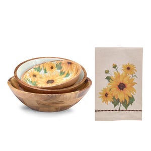 May include: A set of three wooden bowls with a sunflower design. The largest bowl is plain wood, while the middle bowl has a sunflower pattern on the inside. A matching sunflower-themed kitchen towel is also included.