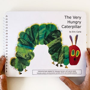 Puede incluir: La portada del libro La Oruga Muy Hambrienta con una ilustración colorida de una oruga sobre un fondo blanco. El libro es de Eric Carle. El texto en la portada dice "Libro interactivo adaptado para aprendices de idiomas con necesidades especiales. Incluye símbolos de comunicación visual (PCS) e imágenes móviles."