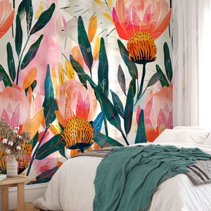 May include: A bedroom with a white wall featuring a large-scale floral mural. The mural features pink, orange, and green flowers with a white background. A bed with a white duvet and a teal blanket is in front of the mural.
