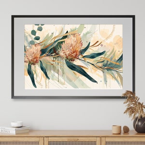 Puede incluir: Una impresión de arte abstracto enmarcada que presenta una pintura de acuarela de flores rosas y naranjas con hojas verdes y acentos dorados sobre un fondo blanco.