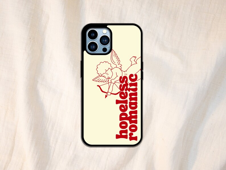 Puede incluir: Una funda de tel&eacute;fono blanca con un contorno rojo de un cupido con una flecha y el texto "hopeless romantic".