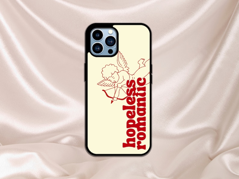 Puede incluir: Una funda de iPhone blanca con un contorno rojo de un cupido con una flecha y el texto "hopeless romantic".