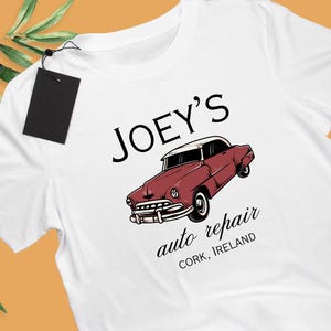 May include: White t-shirt featuring a red vintage car graphic and the text "JOEY'S auto repair CORK, IRELAND".
