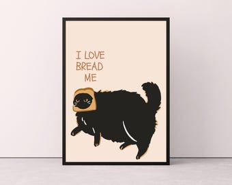 May include: A framed art print featuring a cartoon black cat with a slice of bread on its head. The text "I LOVE BREAD ME" is above the cat. The background is a light beige color.