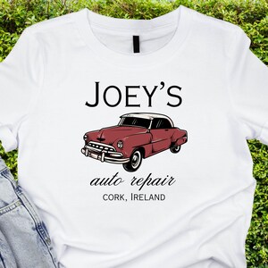 May include: White t-shirt with a red vintage car graphic and the text "JOEY'S auto repair CORK, IRELAND".