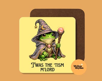 May include: A square coaster with a light yellow background featuring a green frog wearing a purple wizard hat and cloak, holding a wooden staff with a glowing orb. The text 'T'WAS THE 'TISM M'LORD' is printed below the frog illustration.