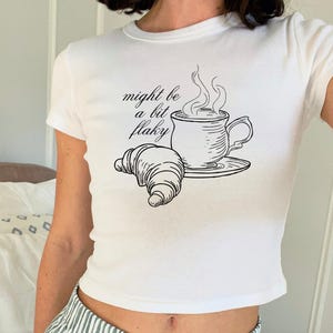 Might Be A Bit Flaky Baby Tee, Funny Slogan T-Shirt, Coffee Club Shirt, Croissant Shirt, Coffee Lover Shirt, Womens White Baby Tee T-Shirt