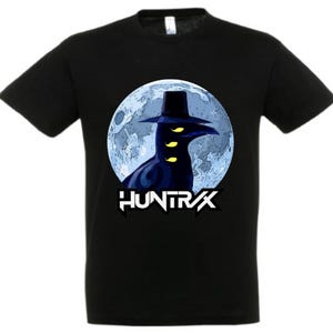 May include: Black t-shirt featuring a graphic of a crow-like figure wearing a hat, set against a blue moon backdrop. The word "HUNTR/X" is printed in white below the image. The shirt is made of a soft material.