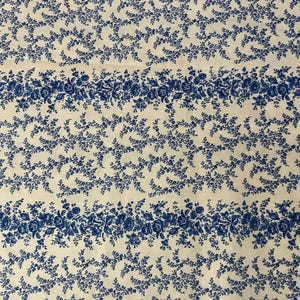 May include: A fabric featuring a repeating pattern of horizontal stripes. The design alternates between wide bands of dense blue floral clusters and narrower bands of delicate blue leafy vines set against a solid off-white background.