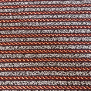 May include: Close-up of a fabric with a repeating pattern of horizontal stripes. Alternating stripes feature a twisted rope design in a reddish-brown color and a speckled white and brown pattern.