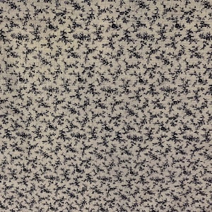 May include: Close-up of a fabric with a repeating pattern of small, dark blue floral shapes on a light beige background. The fabric has a textured appearance, with a grid-like structure visible beneath the floral design.
