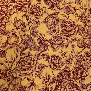 May include: A fabric with a repeating pattern of birds, flowers, and fruit in a deep burgundy color against a golden yellow background. The design features detailed illustrations of peonies, birds, and pomegranates, creating a vintage aesthetic.