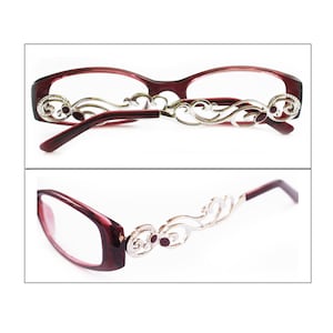 May include: Burgundy-colored eyeglasses with a silver filigree design on the arms. The glasses have a rectangular shape and are shown in two different views.
