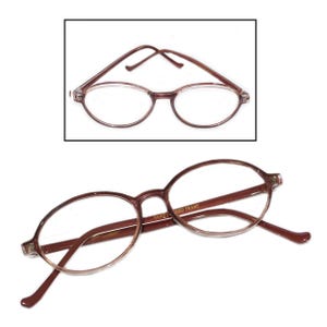 May include: A pair of brown oval-shaped reading glasses with a clear lens. The glasses have a "HAND-FINISHED FRAME" inscription on the side.