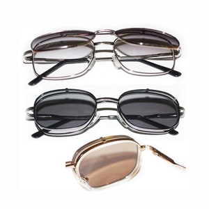 May include: Three pairs of sunglasses with different colored lenses. The top pair has silver frames and gray lenses. The middle pair has black frames and dark gray lenses. The bottom pair has gold frames and brown lenses.