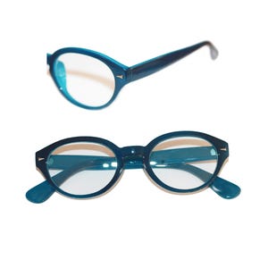 May include: A pair of teal blue oval-shaped eyeglasses with clear lenses.