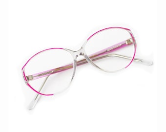 Puede incluir: Gafas de plástico transparente con borde rosa. Las gafas tienen una forma ovalada redondeada.