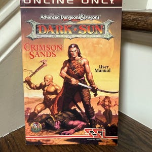 May include: A vintage "Dark Sun: Crimson Sands" user manual for Advanced Dungeons & Dragons, 2nd Edition. The cover features a warrior with a sword, a bald figure with an axe, and a woman. The text "ONLINE ONLY" is at the top.