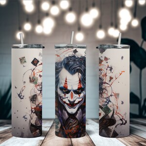 May include: Three stainless steel tumblers with a white background and a colorful graphic of a Joker character with playing cards and paint splatters.