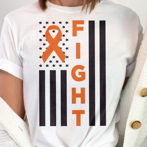 May include: White t-shirt with an orange ribbon and the word "FIGHT" printed on it. The ribbon and the word are on a black and white American flag design.