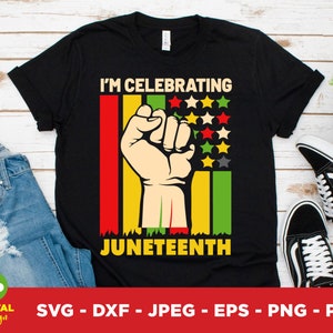 May include: Black t-shirt with a Juneteenth celebration design. The graphic includes a clenched fist, red, yellow, and green stripes, and multi-coloured stars. The text reads "I'M CELEBRATING JUNETEENTH".