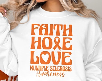 May include: White sweatshirt with an orange graphic that says "Faith Hope Love" with an orange ribbon and heart. Below the graphic is the text "Multiple Sclerosis Awareness."