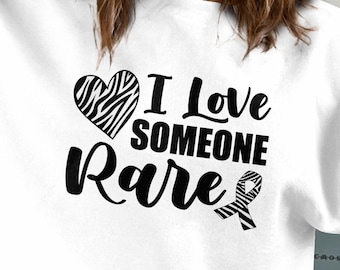 May include: White t-shirt with a black zebra print heart and the text "I Love Someone Rare" with a black zebra print ribbon.