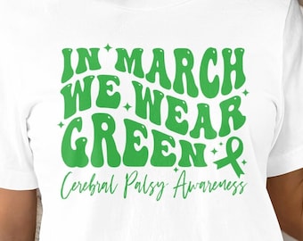 May include: White t-shirt with green text that reads "In March We Wear Green" with a green ribbon. The text "Cerebral Palsy Awareness" is written below the main text.