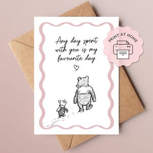 May include: A greeting card with a pink border and the text "Any day spent with you is my favourite day" above a drawing of Winnie the Pooh and Piglet. A pink sticker with a printer icon and the words "Print at Home" is on the right.