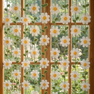 Peut inclure: Rideau de marguerites crochetées avec des pétales blancs et des centres jaunes, enfilées sur des vignes vertes avec des feuilles vertes. Le rideau est suspendu devant une fenêtre en bois. L'image comprend un graphique de téléchargement de modèle PDF rose et blanc.