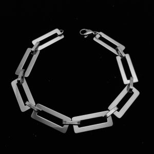 May include: A silver chain bracelet with rectangular links. The bracelet is made of metal and has a polished finish.