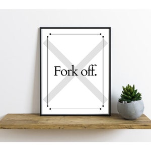 May include: A framed print with the words "Fork off." in black text. The print has a black frame and a white background with a gray X design. A small succulent in a gray pot sits on a wooden shelf.