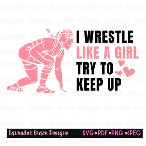 May include: Pink silhouette of a female wrestler in a fighting stance with the text "I wrestle like a girl try to keep up" in black with two pink hearts.