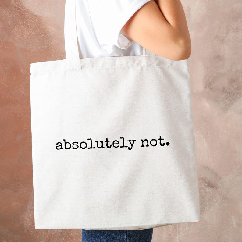 K&ouml;nnte beinhalten: Wei&szlig;e Stofftasche mit schwarzem Text, der "absolut nicht." lautet.