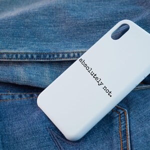 K&ouml;nnte beinhalten: Wei&szlig;e Handyh&uuml;lle mit dem Text "absolut nicht." in Schwarz auf einem Jeansstoff-Hintergrund.