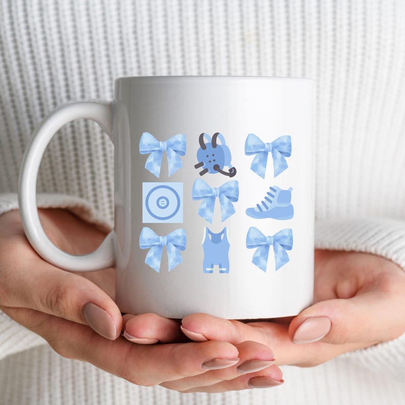 May include: White ceramic mug with a blue and white design. The design features a variety of blue and white icons, including bows, a shoe, a tank top, and a backpack.
