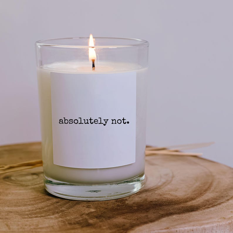 K&ouml;nnte beinhalten: Eine wei&szlig;e Kerze in einem durchsichtigen Glasgef&auml;&szlig; mit einem wei&szlig;en Etikett, auf dem "absolut nicht" steht. Die Kerze ist angez&uuml;ndet und die Flamme ist sichtbar.