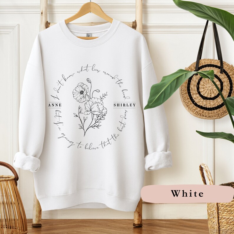 May include: White sweatshirt with a black floral design and the text "I don't know what lies around the bend.  Anne let it in.  Going to believe that the best days... Shirley"