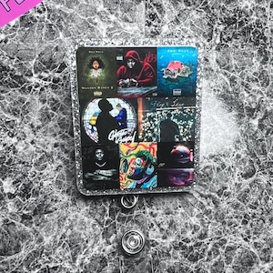 May include: A silver glitter badge holder with a collage of album covers featuring artists like Rod Wave, Kanye West, and  'Ghetto Gospel'.