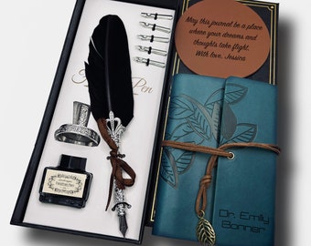 May include: A teal leather journal with a brown leather strap and a leaf charm. The journal is closed and has a personalized inscription that reads "Dr. Emily Bonner". The journal is part of a gift set that includes a black feather pen, a silver inkwell, and a bottle of black ink.