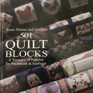 May include: A book titled "501 Quilt Blocks: A Treasury of Patterns for Patchwork & Appliqué" by Better Homes and Gardens. The cover features a variety of colorful quilt blocks.