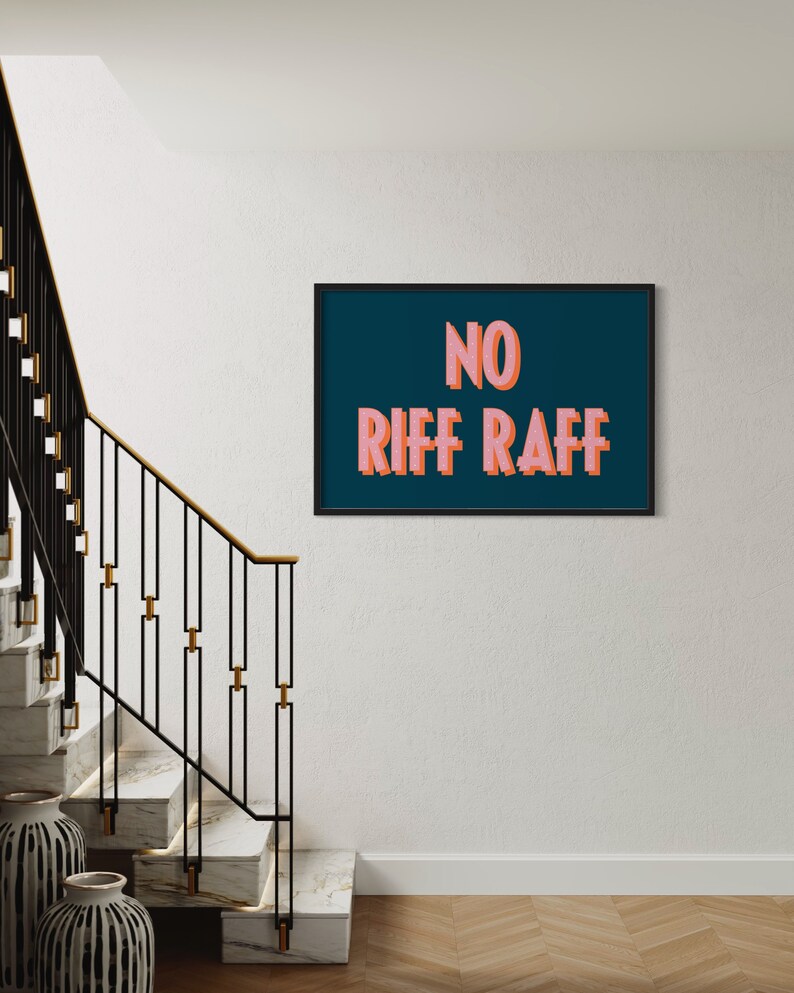 以下が含まれることがあります： 濃い青色の背景に「NO RIFF RAFF」というピンクの文字が書かれた額装されたプリント。プリントは白い壁にかけられています。
