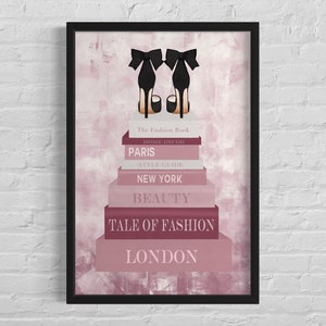 Puede incluir: Una pila de libros con los títulos "The Fashion Book", "Home Decor", "Paris", "Style Guide", "New York", "Beauty", "Tale of Fashion" y "London". Un par de tacones altos negros con un lazo se sienta encima de los libros. El fondo es una acuarela rosa y blanca.