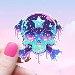 May include: A sticker of a galaxy-themed skull and crossbones with a dripping effect. The skull is blue, green, and purple with a star in the center of the skull. The crossbones are white.