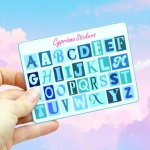 May include: A sticker sheet with the alphabet in shades of blue. Each letter is in a block, within a square. The text "Cypriana Stickers" is written in pink script at the top of the sheet. The background is a sky.