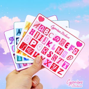 Könnte beinhalten: Vier Blätter mit Alphabet-Aufklebern mit rosa, roten und weißen Buchstaben in einer Retro-Schrift. Die Aufkleber sind mit "Cypriana Stickers" beschriftet.