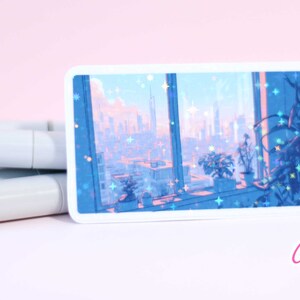 May include: A sticker featuring a city skyline view from a window with a pink and blue color scheme. The sticker has a holographic finish with glitter accents. The sticker is labeled "Cypriana Stickers".