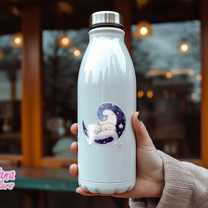 May include: White stainless steel water bottle with a sticker of a white cat sleeping on a crescent moon with stars. The sticker has a purple, blue, and white colour scheme.